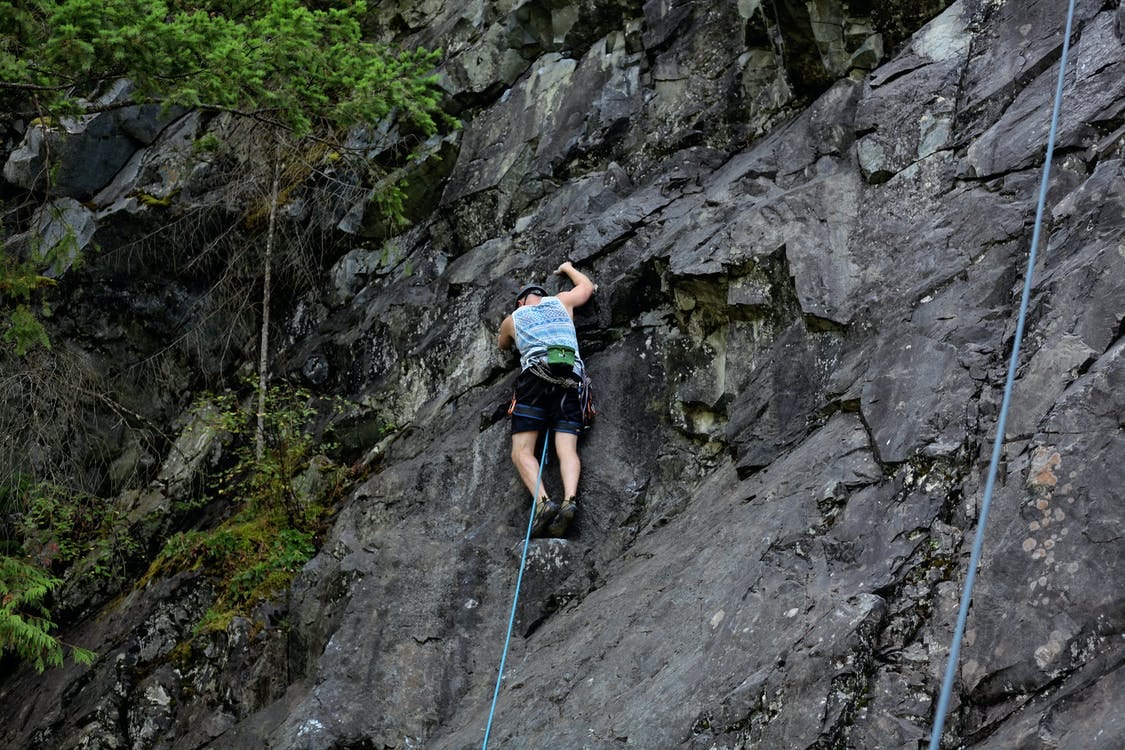 Man Climbing on Rocky Cliff