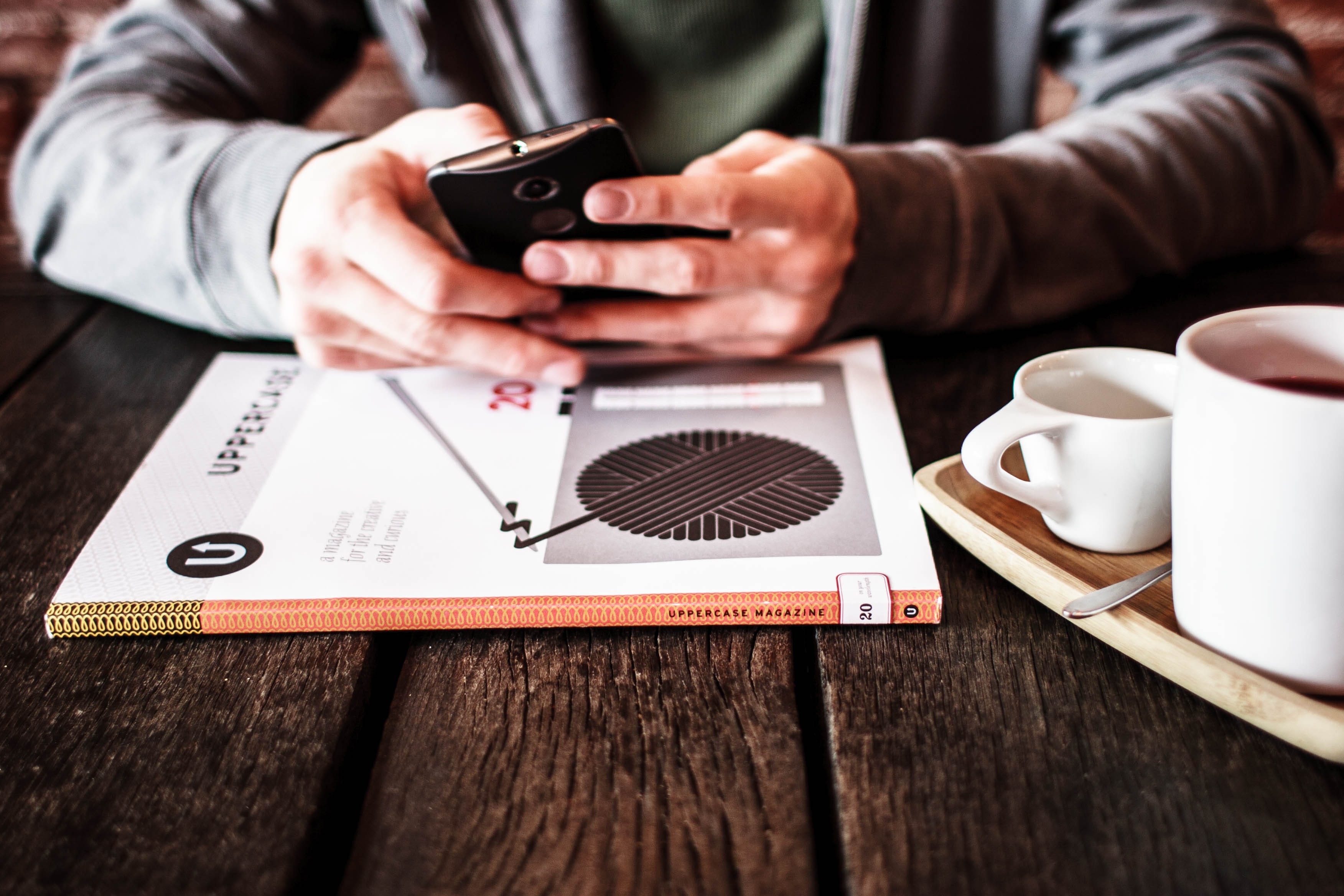 A person issitting on a chair and using phone