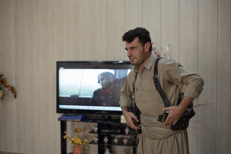 29/09/2015. Chamchamal, Iraq. Hadji Fazer, a volunteer peshmerga fighter, dons belt pouches containing ammunition in his home in Chamchamal Iraq as he and his group prepare to take part in a peshmerga offensive against ISIS held villages to the west of Kirkuk, Iraq. Supported by coalition airstrikes around 3500 peshmerga of the Patriotic Union of Kurdistan (PUK) and the Kurdistan Democratic Party (KDP) engaged in a large offensive to push Islamic State militants out of villages to the west of Kirkuk. During previous offensives ISIS fighters withdrew after sustained coalition air support, but this time in many places militants stayed and fought. The day would see the coalition conduct around 50 airstrikes helping the joint peshmerga force to advance to within a few kilometres of the ISIS stronghold of Hawija and re-take around 17 villages. Around 20 peshmerga lost their lives to improvised explosive devices left by the Islamic State, reports suggest that between 40 and 150 militants were killed.