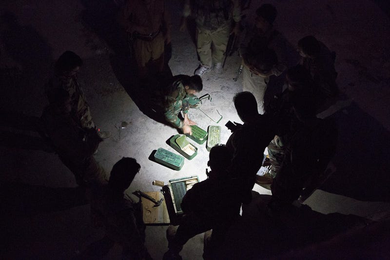 30/09/2015. Kirkuk, Iraq. KDP peshmerga fighters distribute extra ammunition as they prepare to leave their base and take part in a large offensive to capture several villages held by the Islamic State to the west of Kirkuk, Iraq. Supported by coalition airstrikes around 3500 peshmerga of the Patriotic Union of Kurdistan (PUK) and the Kurdistan Democratic Party (KDP) engaged in a large offensive to push Islamic State militants out of villages to the west of Kirkuk. During previous offensives ISIS fighters withdrew after sustained coalition air support, but this time in many places militants stayed and fought. The day would see the coalition conduct around 50 airstrikes helping the joint peshmerga force to advance to within a few kilometres of the ISIS stronghold of Hawija and re-take around 17 villages. Around 20 peshmerga lost their lives to improvised explosive devices left by the Islamic State, reports suggest that between 40 and 150 militants were killed.