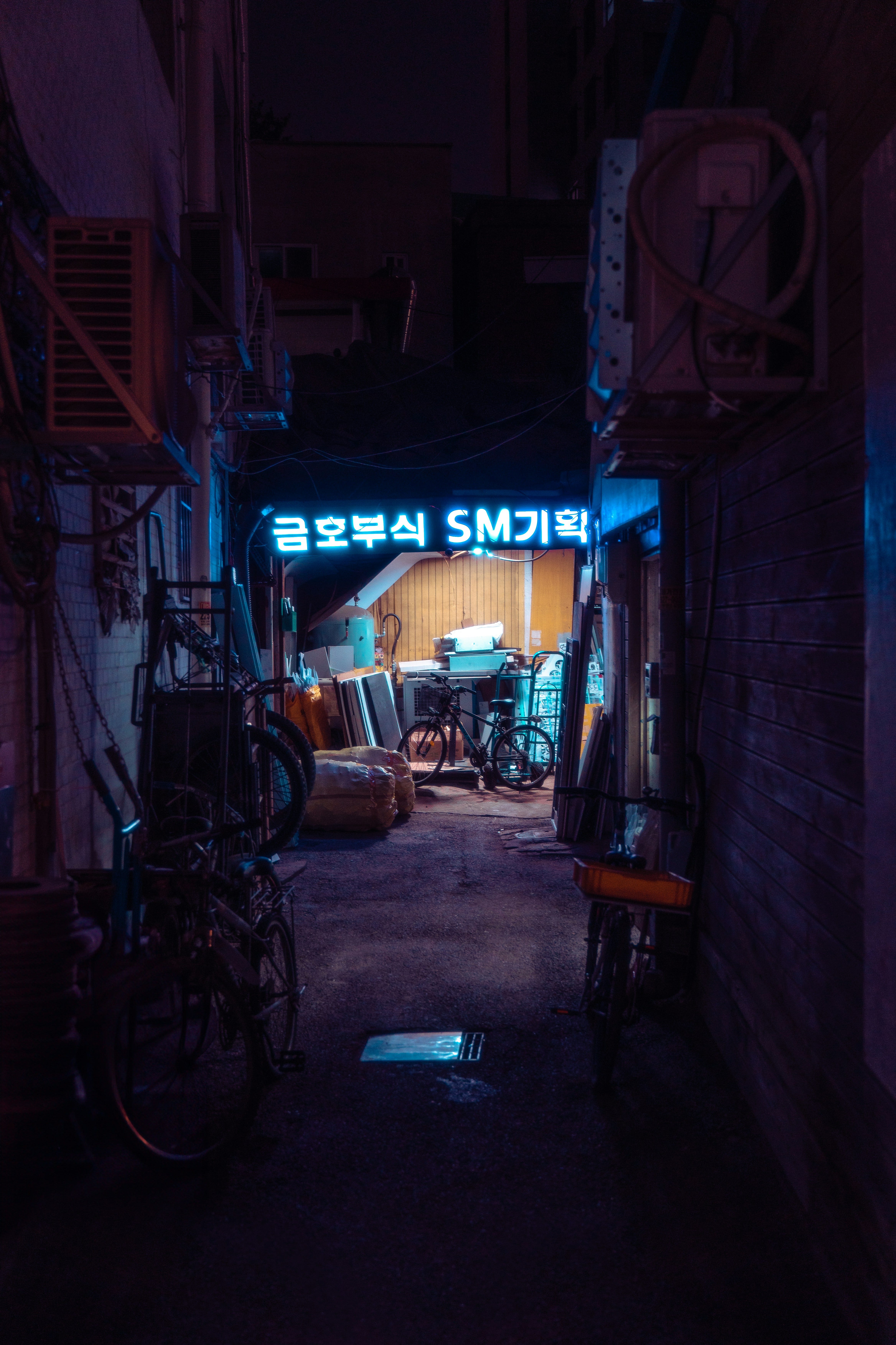 a dark alley way with a neon sign