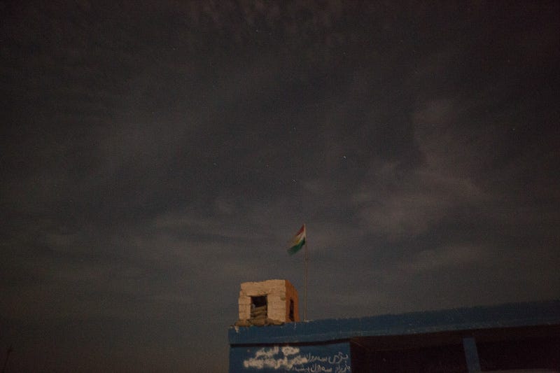 29/09/2015. Kirkuk, Iraq. The Kurdish flag flies over a small peshmerga base ahead of an offensive to retake several ISIS held villages west of Kirkuk, Iraq. Supported by coalition airstrikes around 3500 peshmerga of the Patriotic Union of Kurdistan (PUK) and the Kurdistan Democratic Party (KDP) engaged in a large offensive to push Islamic State militants out of villages to the west of Kirkuk. During previous offensives ISIS fighters withdrew after sustained coalition air support, but this time in many places militants stayed and fought. The day would see the coalition conduct around 50 airstrikes helping the joint peshmerga force to advance to within a few kilometres of the ISIS stronghold of Hawija and re-take around 17 villages. Around 20 peshmerga lost their lives to improvised explosive devices left by the Islamic State, reports suggest that between 40 and 150 militants were killed.