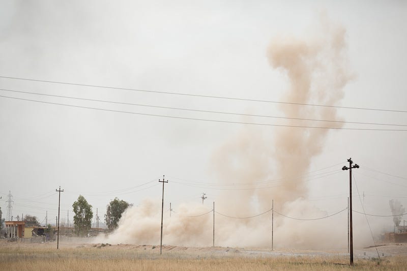 30/09/2015. Kirkuk, Iraq. A cloud of dust marks the spot where three peshmerga were fatally injured by an Islamic State improvised explosive device on the edge of Mansuriya village during an offensive to push militants out of several villages to the west of Kirkuk, Iraq. Supported by coalition airstrikes around 3500 peshmerga of the Patriotic Union of Kurdistan (PUK) and the Kurdistan Democratic Party (KDP) engaged in a large offensive to push Islamic State militants out of villages to the west of Kirkuk. During previous offensives ISIS fighters withdrew after sustained coalition air support, but this time in many places militants stayed and fought. The day would see the coalition conduct around 50 airstrikes helping the joint peshmerga force to advance to within a few kilometres of the ISIS stronghold of Hawija and re-take around 17 villages. Around 20 peshmerga lost their lives to improvised explosive devices left by the Islamic State, reports suggest that between 40 and 150 militants were killed.