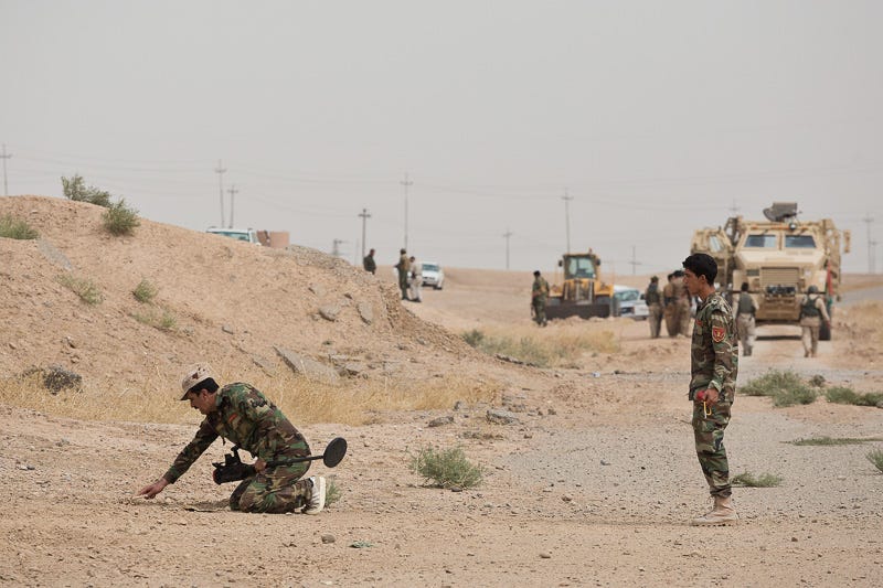 30/09/2015. Kirkuk, Iraq. Peshmerga engineers check for ISIS improvised explosive devices on a road outside Mansuriya village. Supported by coalition airstrikes around 3500 peshmerga of the Patriotic Union of Kurdistan (PUK) and the Kurdistan Democratic Party (KDP) engaged in a large offensive to push Islamic State militants out of villages to the west of Kirkuk. During previous offensives ISIS fighters withdrew after sustained coalition air support, but this time in many places militants stayed and fought. The day would see the coalition conduct around 50 airstrikes helping the joint peshmerga force to advance to within a few kilometres of the ISIS stronghold of Hawija and re-take around 17 villages. Around 20 peshmerga lost their lives to improvised explosive devices left by the Islamic State, reports suggest that between 40 and 150 militants were killed.