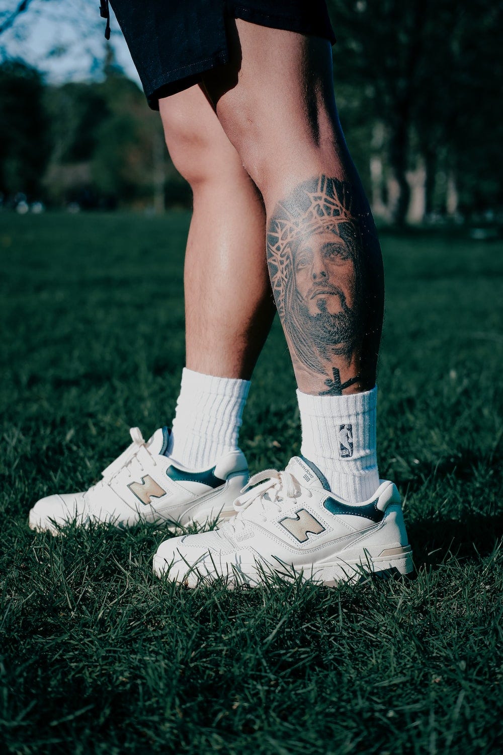 A man with a Jesus tatoo on his leg (calf).