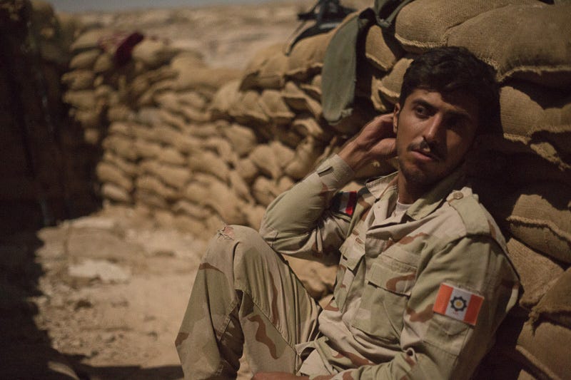 02/09/2015. Bashiqa, Iraq. Hazhar, an Iranian Kurdish fighter belonging PAK, a Kurdish anti-Iranian regime group, relaxes during a shift on guard at his unit's position on Bashiqa Mountain, Iraq. PAK fighters serve along side Iraqi Kurdish peshmerga along defensive positions on the mountain. Bashiqa Mountain, towering over the town of the same name, is now a heavily fortified front line. Kurdish peshmerga, having withdrawn to the mountain after the August 2014 ISIS offensive, now watch over Islamic State held territory from their sandbagged high-ground positions. Regular exchanges of fire take place between the Kurds and the Islamic militants with the occupied Iraqi city of Mosul forming the backdrop. The town of Bashiqa, a formerly mixed town that had a population of Yazidi, Kurd, Arab and Shabak, now lies empty apart from insurgents. Along with several other urban sprawls the town forms one of the gateways to Iraq's second largest city that will need to be dealt with should the Kurds be called to advance on Mosul.