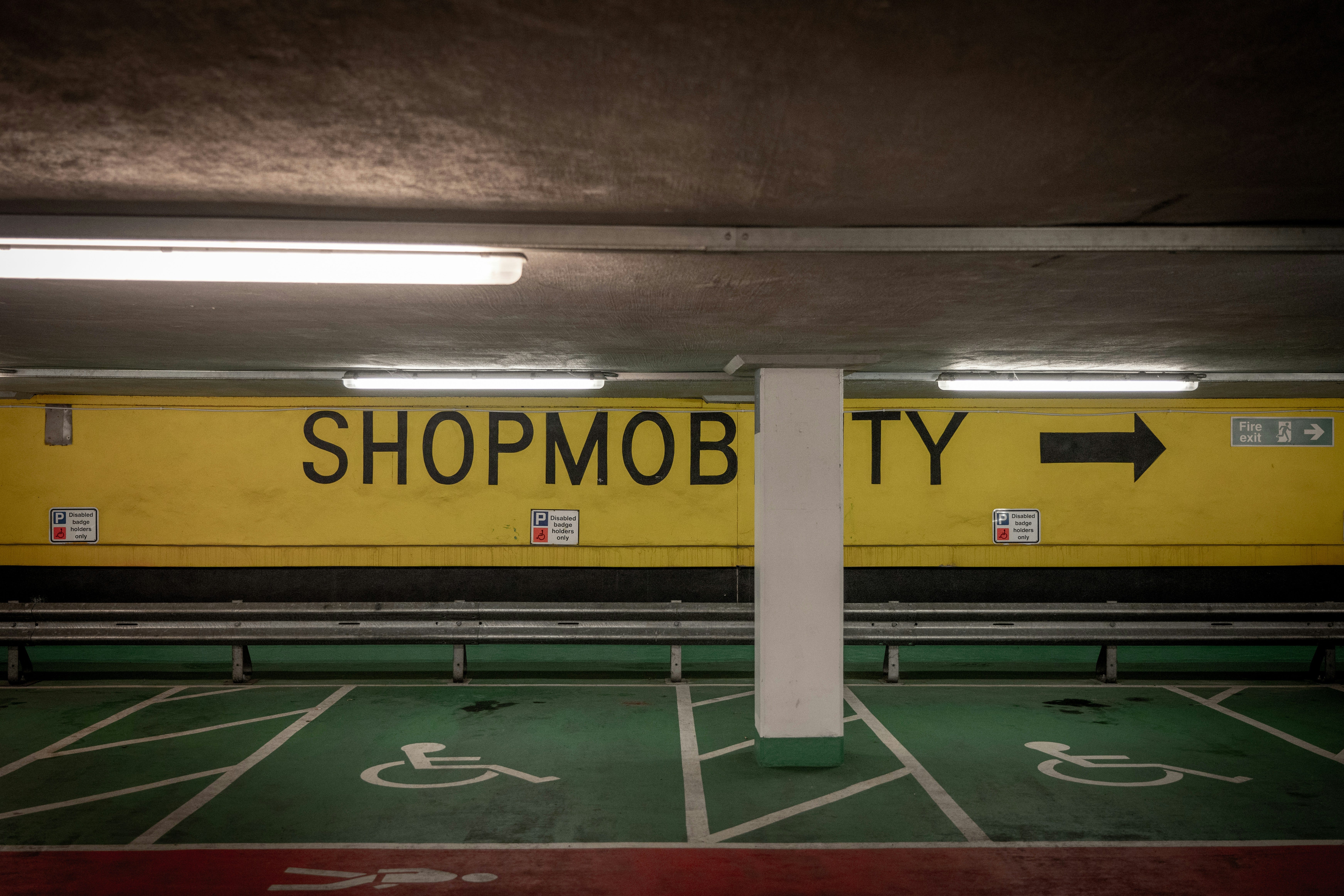 a yellow train traveling through a tunnel next to a parking lot