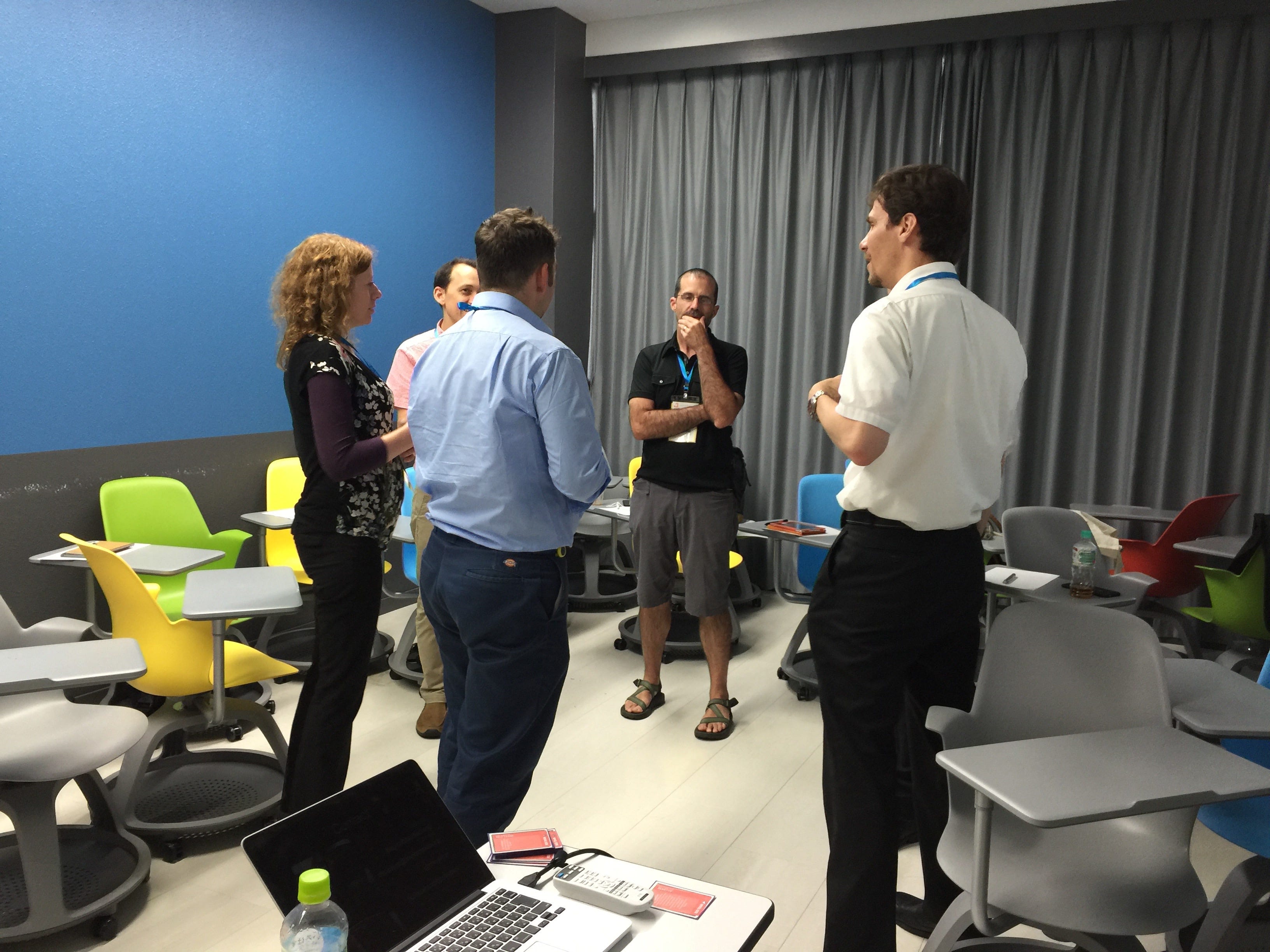 A group of attendees discuss who to send to the other "room" in a game of Two Rooms and a Boom.