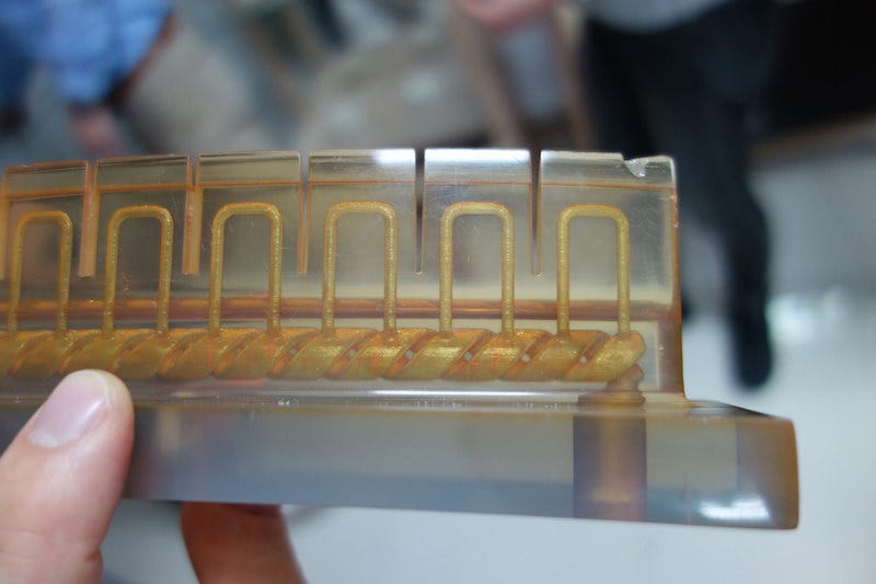Innovative practices aren't just applied as a service, but also to in-house products. This photo shows how 3D printed molds can include cooling channels that will cool the final molded plastic piece 20% faster, which increases the production output significantly compared to traditional molding. Image: Peter Bihr (CC by-nc-sa)