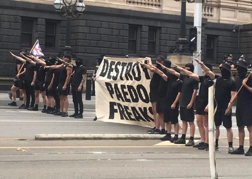 Neonazis from Australia's National Socialist Network do the fascist salute carrying an Australian national flag and a banner saying "Destroy Paedo Freaks" at the Kellie Jay Keen Standing For Women rally in Victoria.