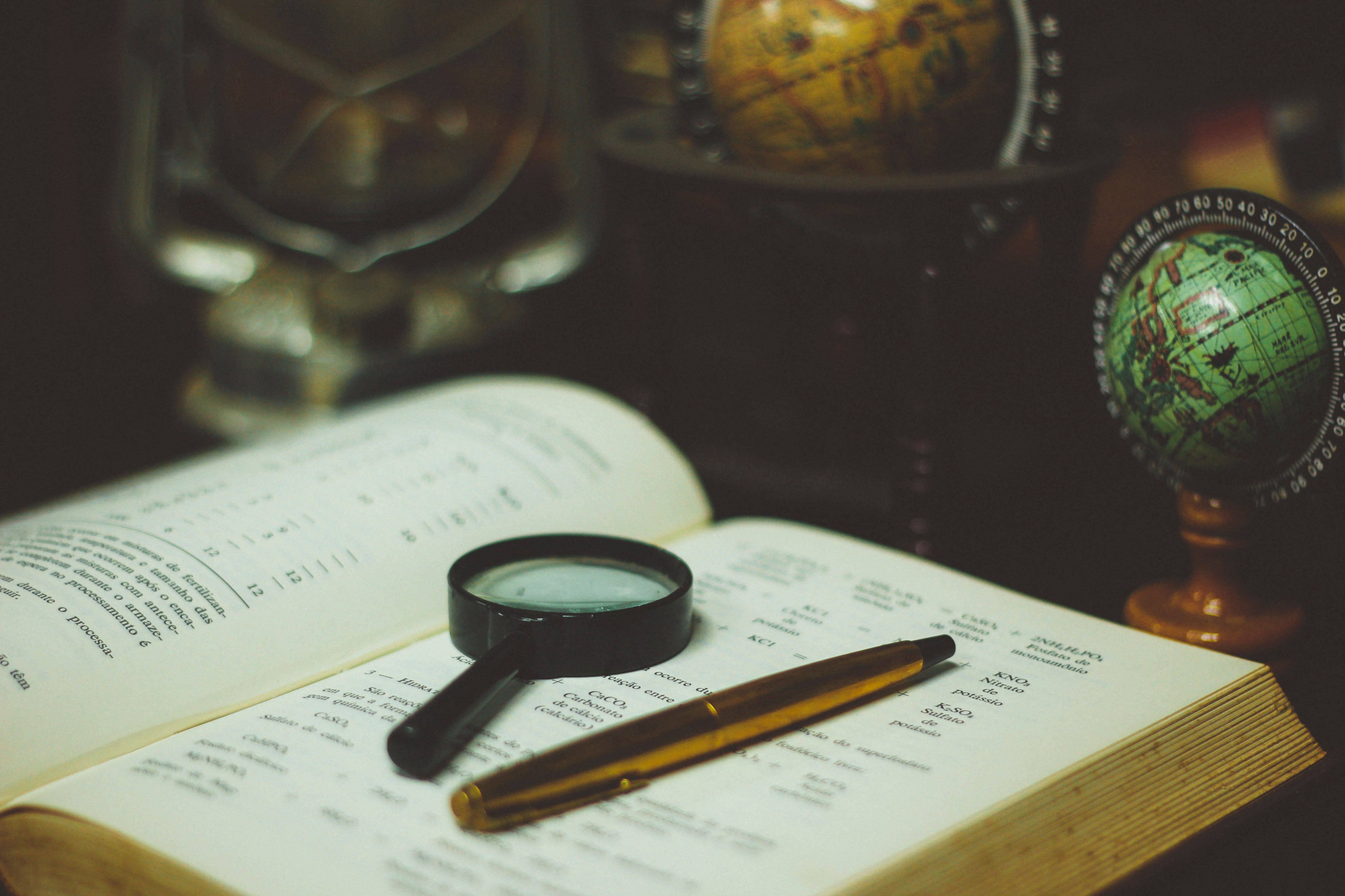 Image of a book with pen and magnifier