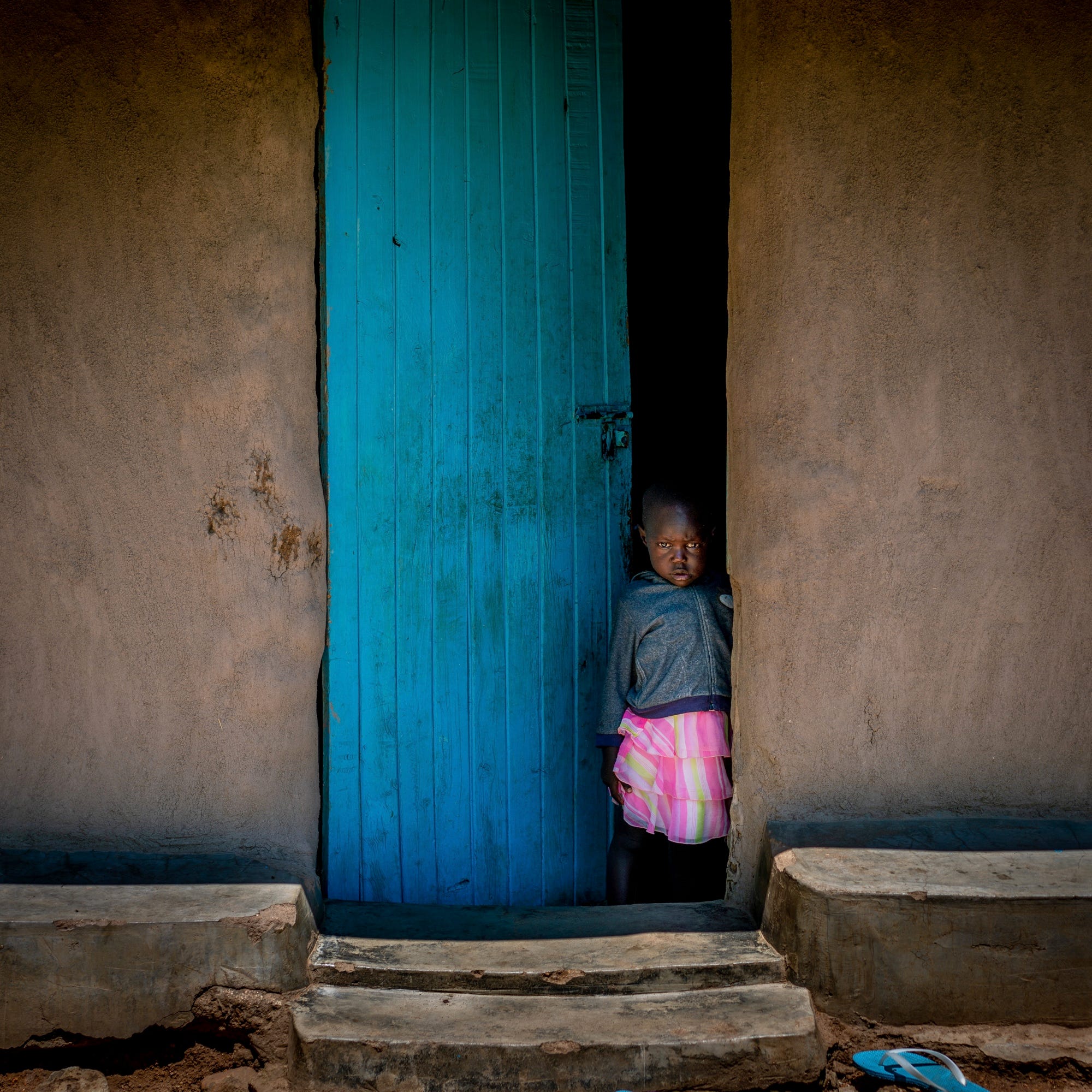 Girl with malaria, looking at us from afar.