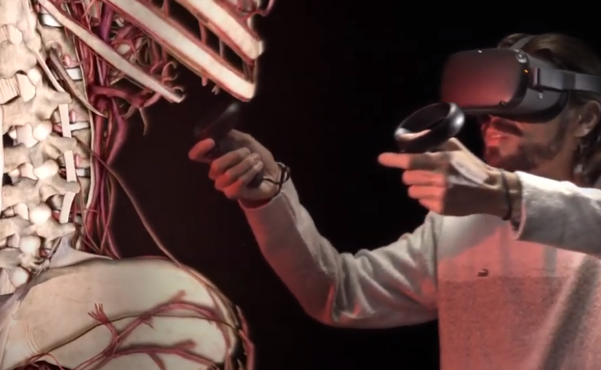 A man using a holographic headset visualizes parts of the human body in an amplified proportion. Frame extracted from a video available on Medroom page: https://www.medroom.com.br